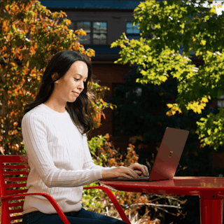 A Tufts University student types on their laptop.